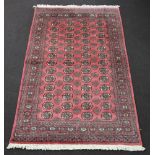 A pink and brown ground Bokhara rug with 39 octagons to the centre 240cm x 152cm