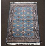A blue and white ground Bokhara rug with 14 stylised diamonds to the centre within a multi row