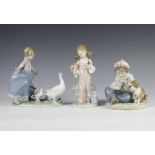 A Lladro figure of a seated boy and puppy 14cm, a ditto of a girl with bird 5217 18cm and a ditto of
