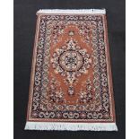 A brown and black ground machine made Persian style rug with central medallion 90cm x 150cm