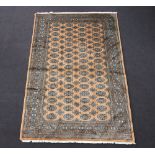 A gold and black ground Bokhara rug with 62 octagons to the centre 242cm x 160cm