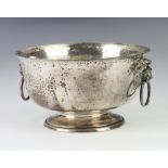 An Edwardian hammered pattern silver pedestal bowl with lion ring drop handles, London 1908, 456