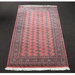 A pink, green and white ground Bokhara rug with 55 octagons to the centre 255cm x 158cm