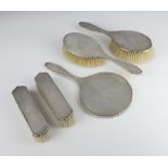 A 5 piece engine turned silver backed dressing table set comprising hand mirror, 2 clothes