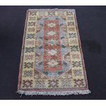 A Turkish Caucasian style yellow and blue ground rug with 5 diamonds to the centre 208cm x 122cm