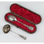 A Victorian silver spoon Birmingham 1884 with engraved decoration cased, together with a sifter