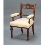 An Edwardian carved walnut bar back open armchair with bobbin turned decoration, upholstered arms