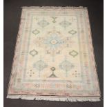 A white, pink and green ground Turkish Caucasian style carpet with central medallion within multi