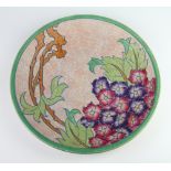 A Charlotte Rhead platter decorated with stylised flowers, signature mark to the base 32cm