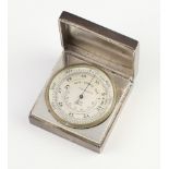 A silver desk top barometer contained in a square case with engraved presentation inscription London