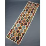 A white, brown, tan and black ground Chobi Kilim runner with all over geometric designs 295cm x 82cm