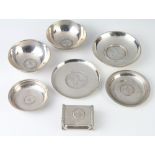 A white metal coin set dish 9cm, 5 others and a match sleeve holder, gross weight 296 grams