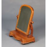 A Victorian arched plate dressing table mirror contained in a mahogany swing frame the base of
