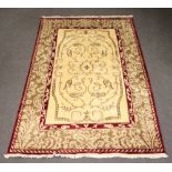 A wool and silk red, white and brown ground Eastern rug with all-over geometric design to the centre