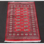 A red and white ground Bokhara rug with 16 octagons to the centre 152cm x 91cm