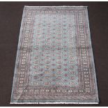 A blue and white ground Bokhara rug with 64 octagons to the centre 240cm x 153cm