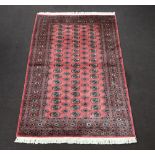 A pink and white ground Bokhara carpet with 54 octagons to the centre 246cm x 158cm