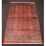 A red ground Bokhara rug with 68 octagons to the centre 250cm x 156cm