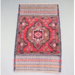 A red and blue ground Belouche rug with central medallion 140cm x 83cm