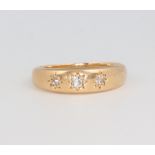 A yellow metal 18ct 3 stone diamond gypsy ring, size M 1/2, 4 grams