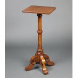 A Victorian square light oak jardiniere stand raised on a turned and fluted column with tripod