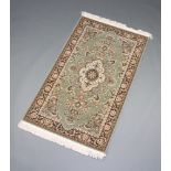 A green and grey ground Persian style machine made rug 152cm x 90cm
