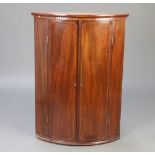 A Georgian inlaid mahogany bow front hanging corner cabinet with moulded and dentil cornice, the