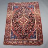 A blue and red ground North West Persian rug with central medallion 165cm x 113cm Some staining,