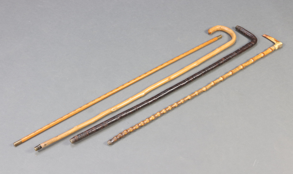 A bamboo cane with stag horn handle, a yard stick together with 2 other canes