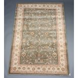 A green and gold ground machine made rug 199cm x 133cm