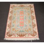 A Turkish Caucasian style orange, green and brown ground rug with 5 stylised octagons to the