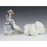 A Lladro figure of a girl with goose 5034 23cm together with a pair of doves 12cm