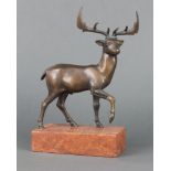 An Art Deco style bronze figure of a walking stag raised on a pink veined marble base 27cm x 18cm