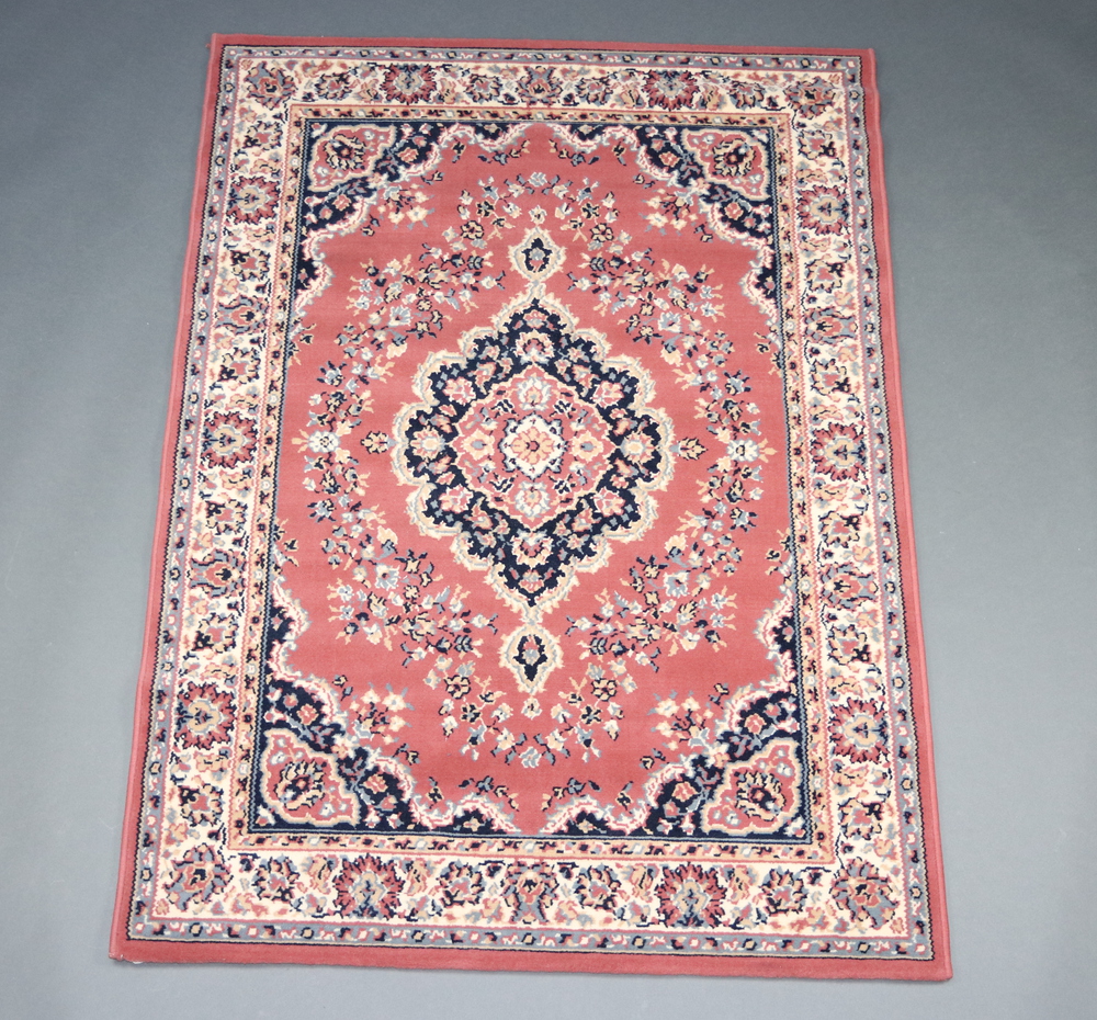 A pink and black ground Persian style rug with central medallion 172cm x 119cm