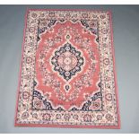 A pink and black ground Persian style rug with central medallion 172cm x 119cm