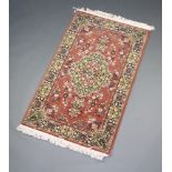 A brown and white ground floral patterned Persia style machine made rug with central medallion 151cm