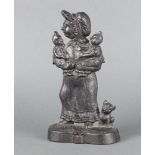 A Victorian style cast iron door stop in the form of a standing mother, child and dog 30cm h x