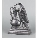 A Victorian cast iron door stop in the form of a bird drinking from a ewer, raised on a shaped