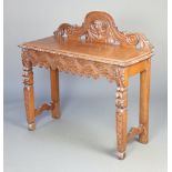 A Victorian carved and pierced oak hall table with raised back, having a wavy apron and on shaped