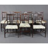 A set of 7 19th Century beech framed stick and bar back dining chairs with over stuffed seats raised