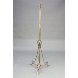 A brass standard lamp raised on a tripod base 142cm h x 53cm