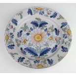 An 18th Century English polychrome Delft shallow bowl decorated with stylised flowers 33cm There