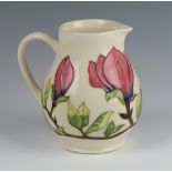 A modern Moorcroft cream ground baluster jug decorated with flowers 14cm