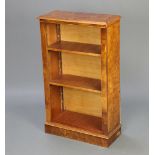A Victorian style figured walnut bookcase fitted adjustable shelves raised on a platform base