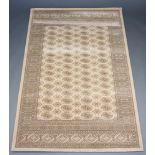 A sand ground machine made Bokhara style rug with 72 medallions to the centre 201cm x 133cm