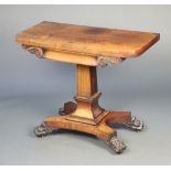 A William IV rosewood D shaped card table raised on a square column and triform base with paw feet