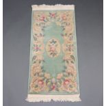 A green ground and floral pattern Chinese rug with central medallion 118cm x 60cm Fringe reduced,