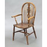 A 19th Century elm Windsor stick and wheel back chair raised on turned supports with H framed