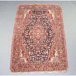 A blue and red ground North West Persian rug with central medallion 174cm x 112cm Signs of wear,