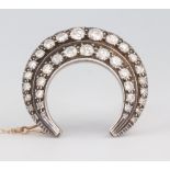 A 9ct and silver double crescent diamond brooch, 30mm, approx. 2.5ct, 10 grams